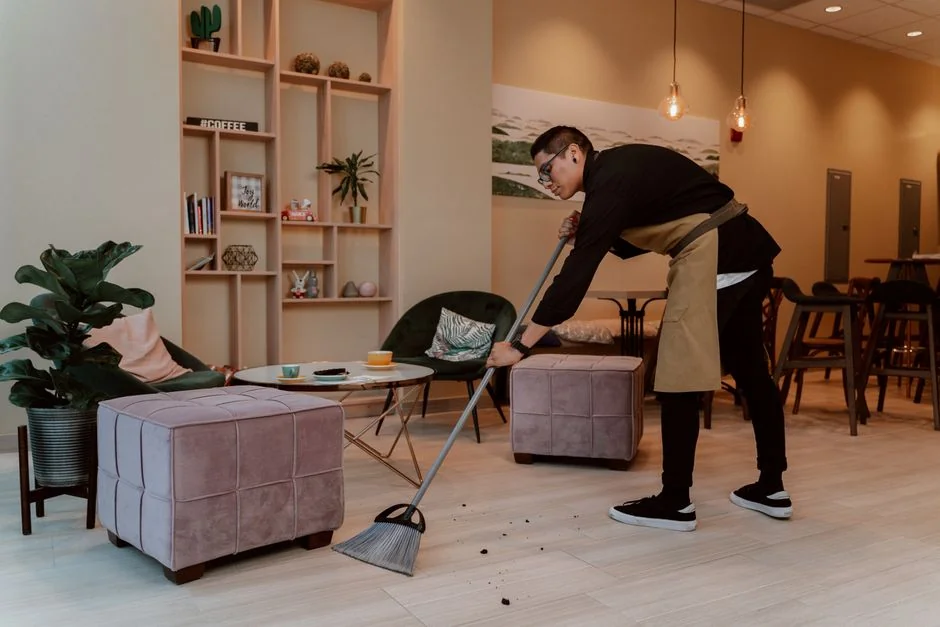Person using spray bottle and cloth for cleaning a kitchen shelf, ensuring hygiene and cleanliness.
